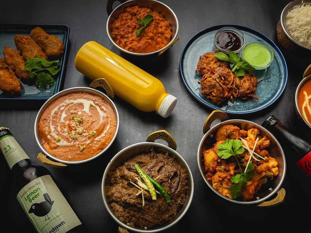 Udvalg af indiske retter med mango lassi og ris fra Om Indisk